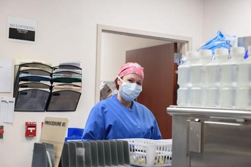  Image of smiling surgical nurse with mask working on post-op floor of hospital.