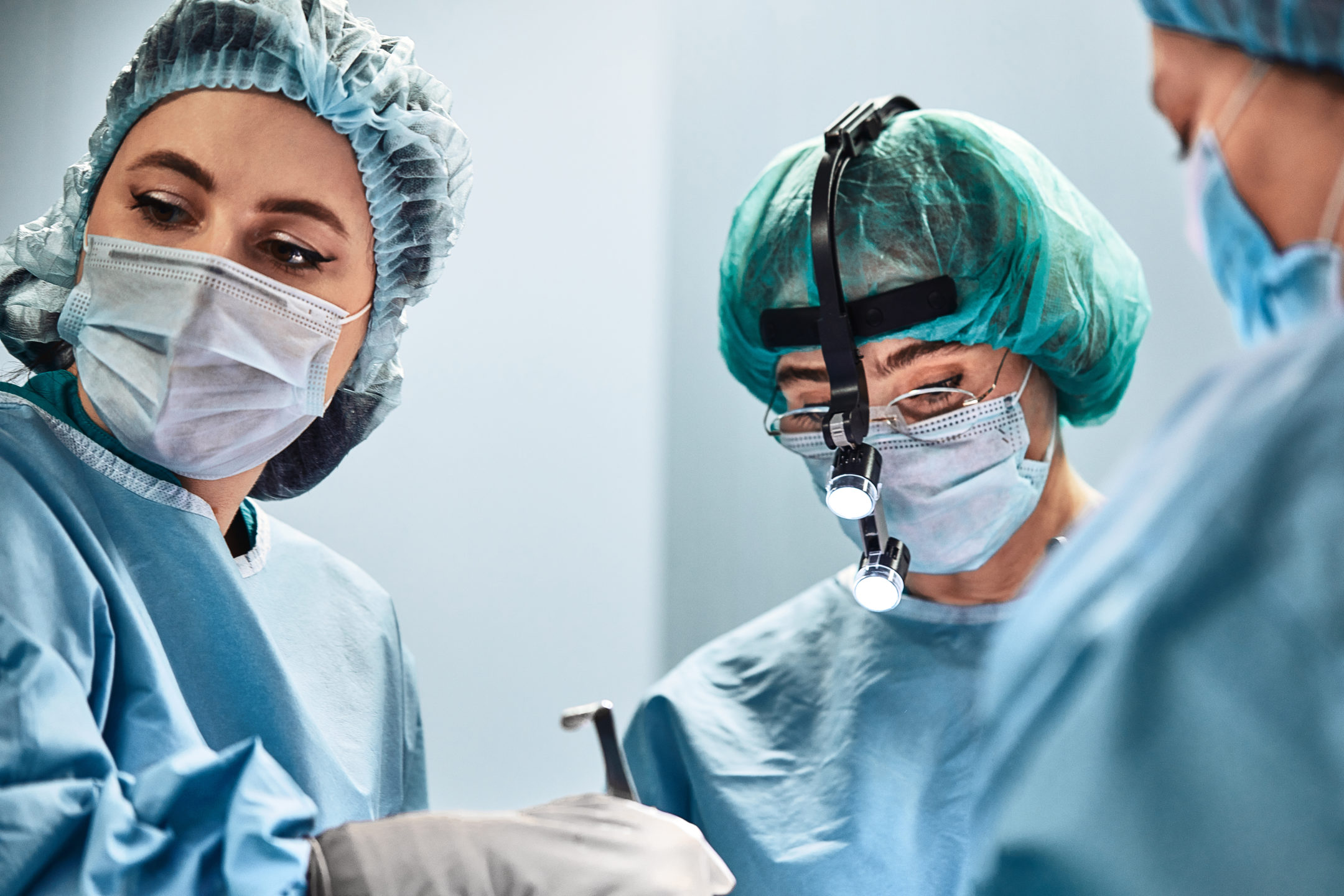 A surgeon and assistants work on a patient. 