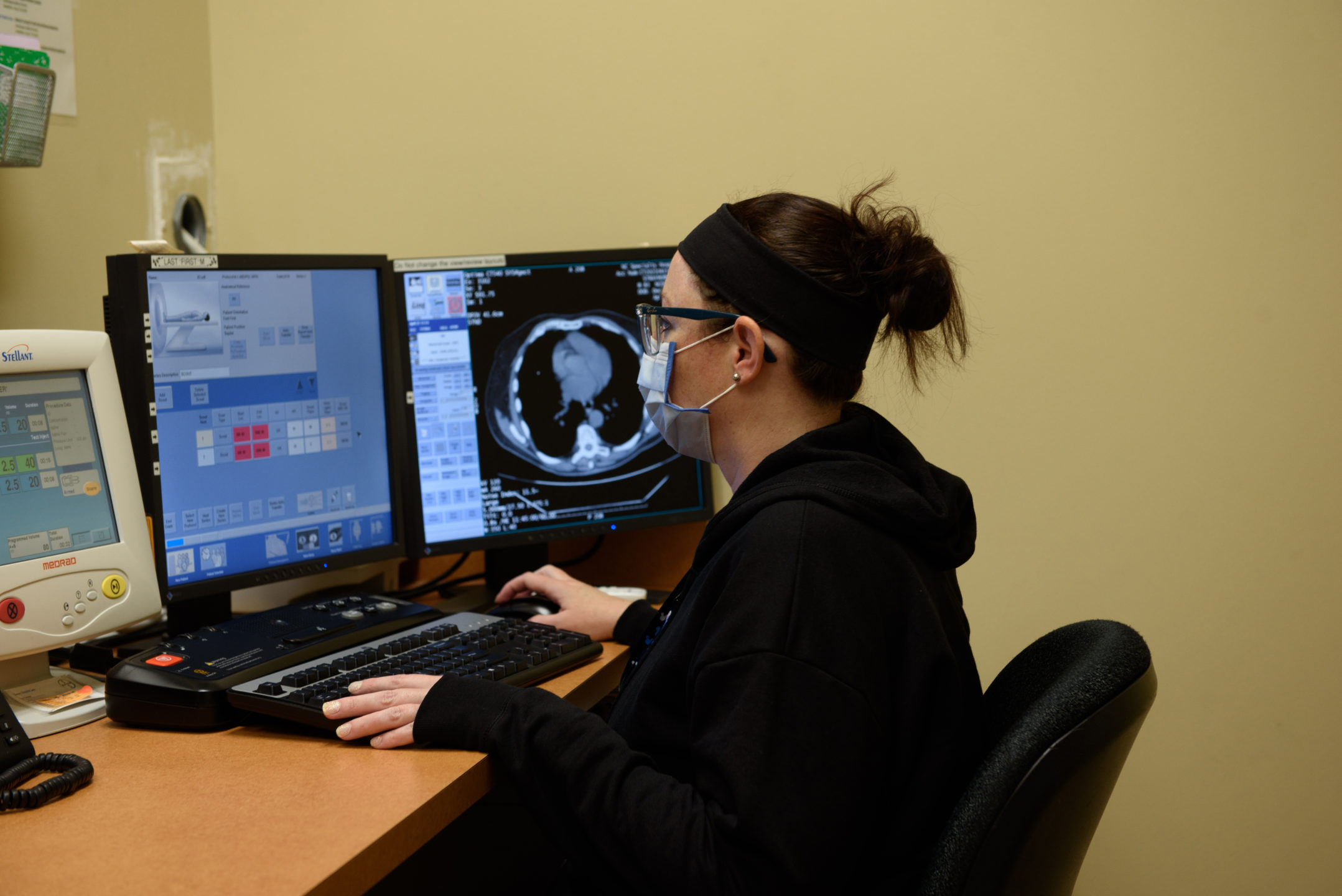 A radiology technician looks at CT images on a computer screen. 