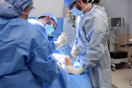 A surgeon works on a patient as two nurses or techs assist. 