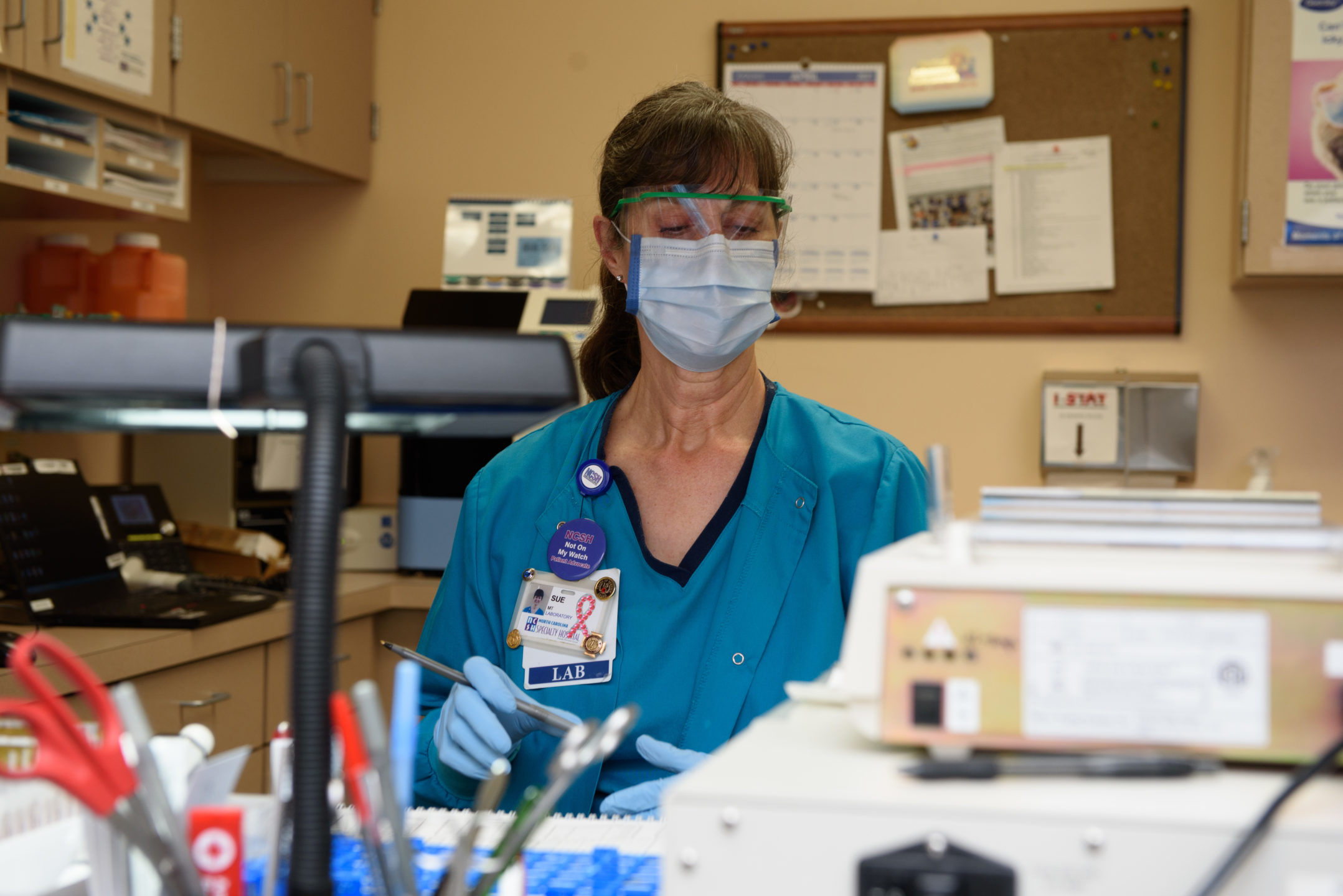  Image of a lab technician working behind a desk.