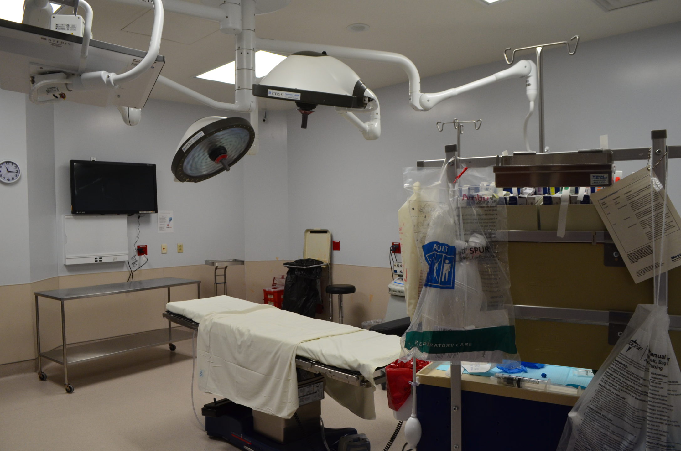  A view of a prepped operating room shows surgical equipment and instruments. 