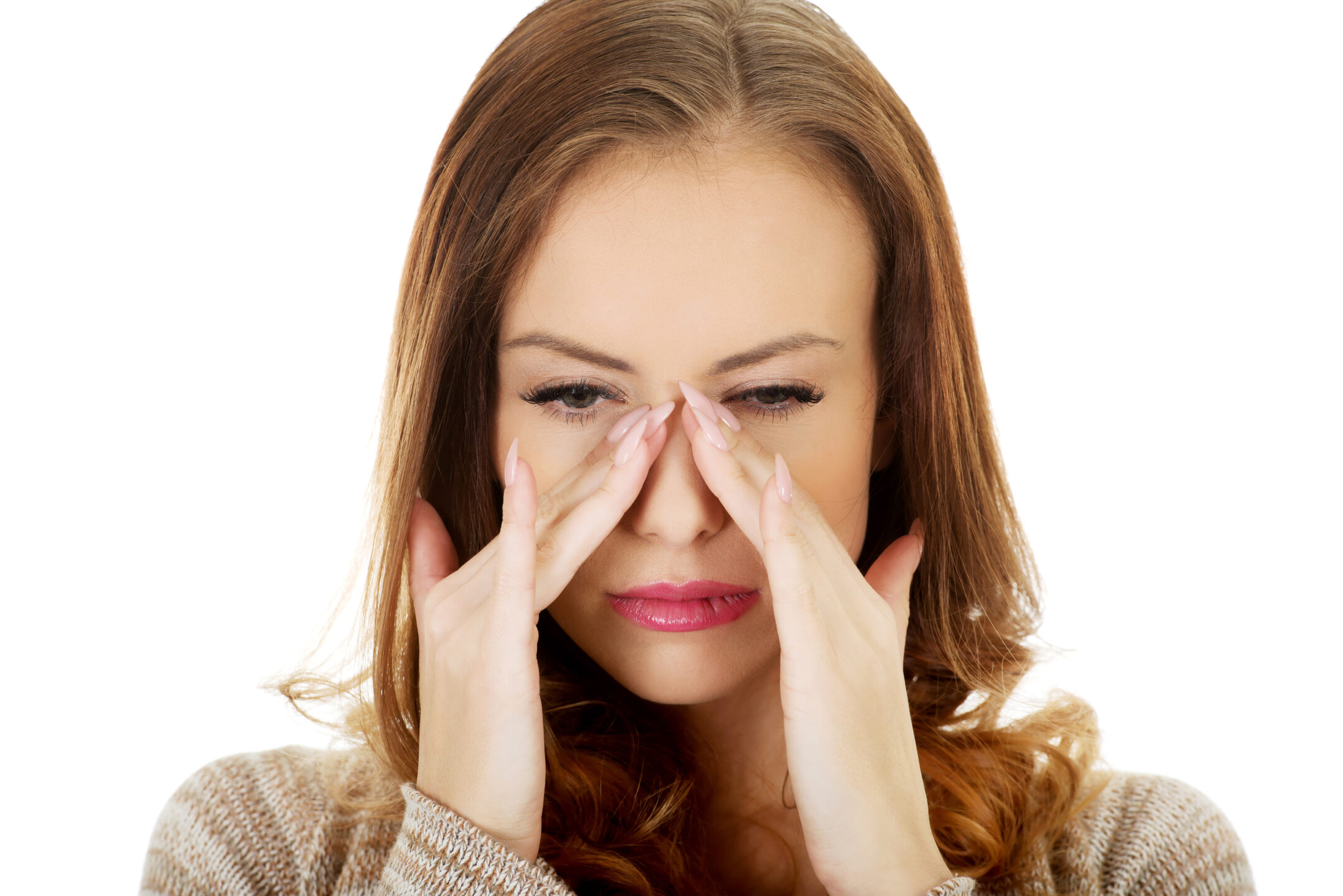 A young woman with sinus pain holds her fingers to her nose and wonders about septoplasty recovery day by day.