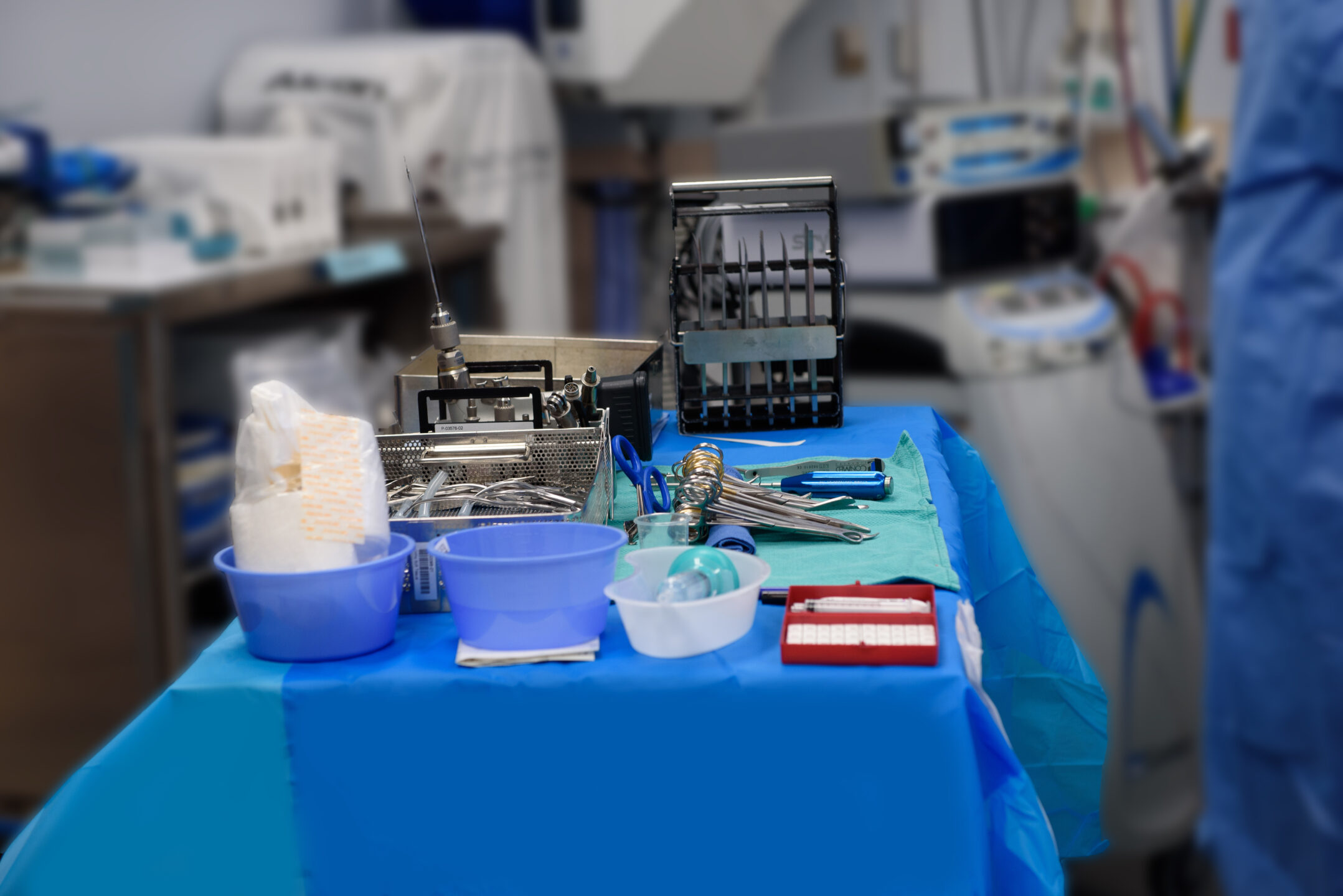 Surgical tools and materials sit on a table in preparation for a procedure. 