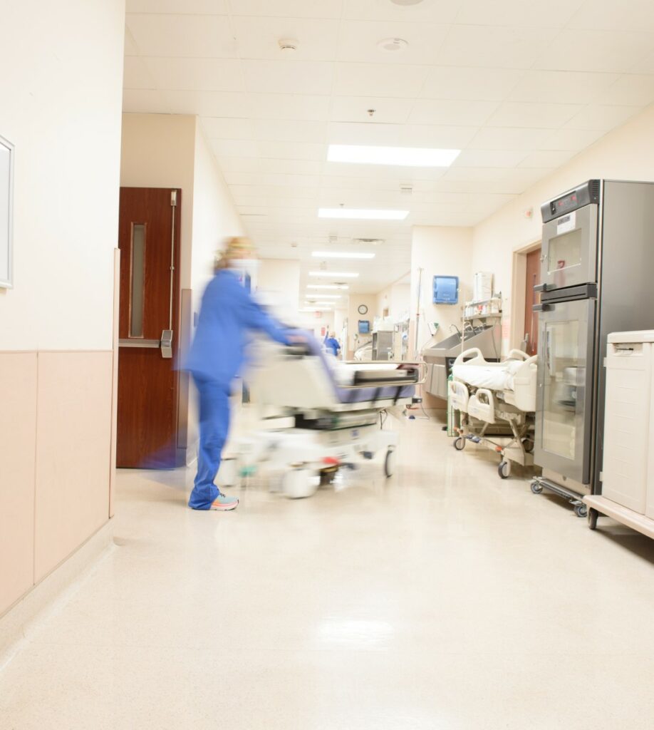 A staff member pushes a bed through a hallway in an orthopedic specialty hospital. 